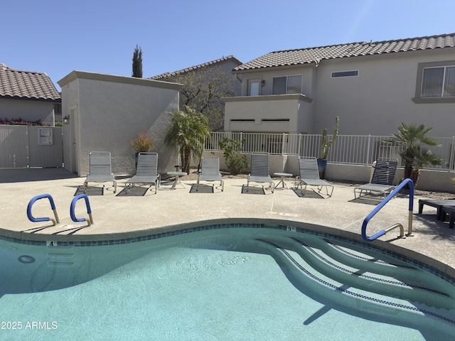 community pool with a patio and fence