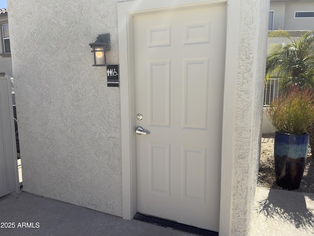 entrance to property with stucco siding