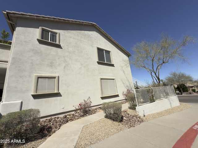 view of home's exterior with stucco siding and a tiled roof