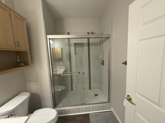 bathroom with a shower stall and toilet