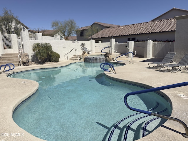 view of pool with a fenced backyard, a pool with connected hot tub, and a patio