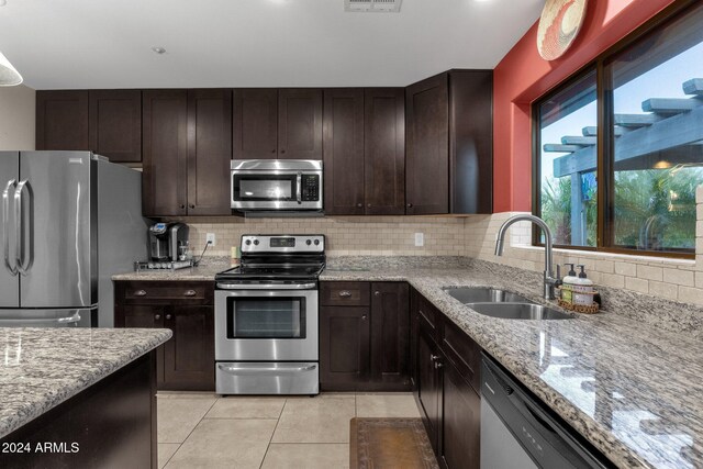 15019 N Mayflower Dr, Fountain Hills, AZ 85268 - kitchen featuring stainless steel appliances, a sink, backsplash, light tile patterned floors, and light stone countertops
