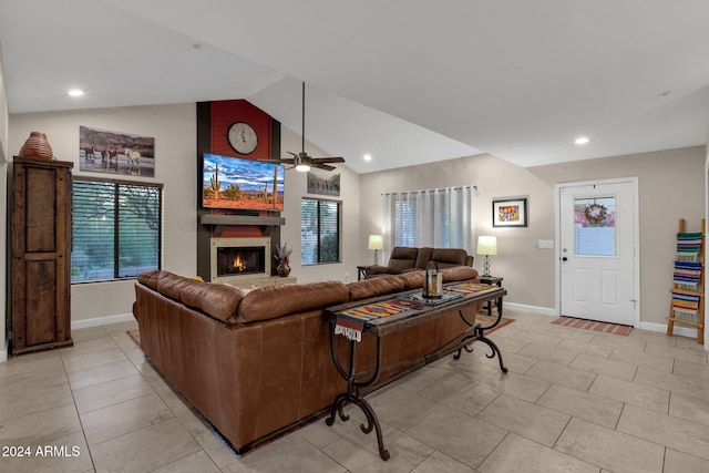 living room with light tile patterned floors, a large fireplace, vaulted ceiling, and ceiling fan