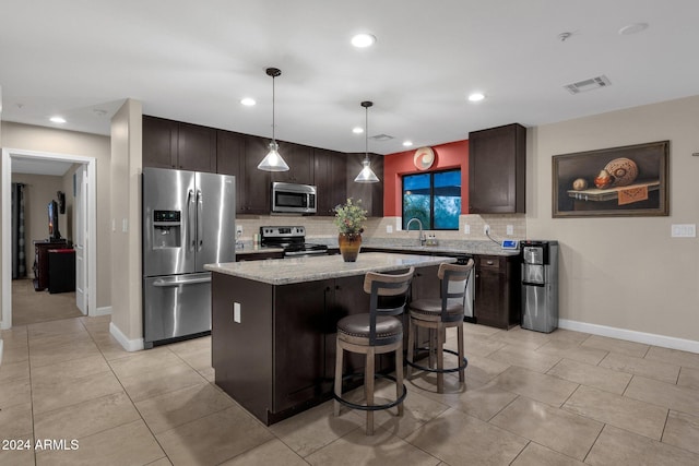 kitchen featuring a kitchen island, dark brown cabinetry, hanging light fixtures, and appliances with stainless steel finishes