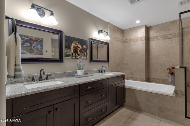 bathroom featuring tile patterned floors, vanity, and a relaxing tiled tub