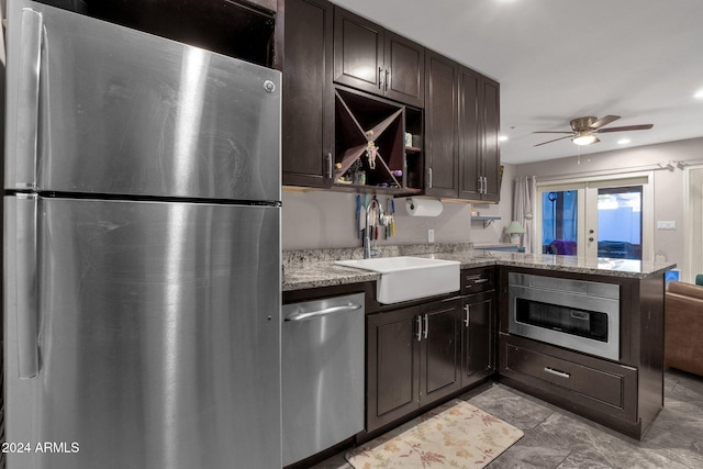 kitchen with kitchen peninsula, appliances with stainless steel finishes, dark brown cabinets, ceiling fan, and sink