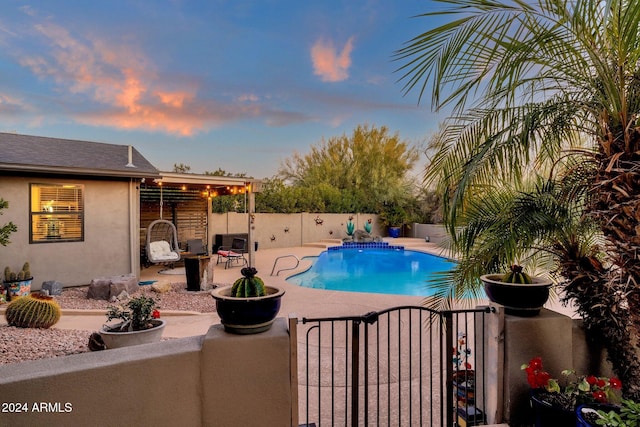 pool at dusk featuring a patio