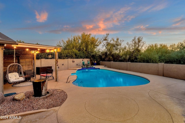 pool at dusk with a patio area