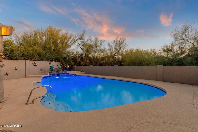 pool at dusk with a patio