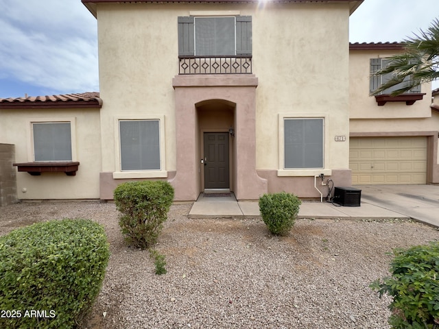 property entrance with driveway, an attached garage, and stucco siding