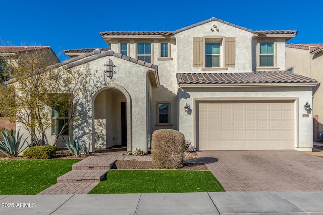 mediterranean / spanish-style house with a garage