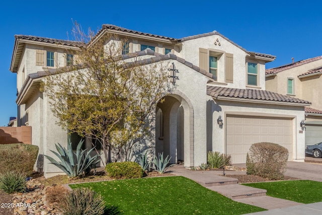 mediterranean / spanish home with a garage and a front yard