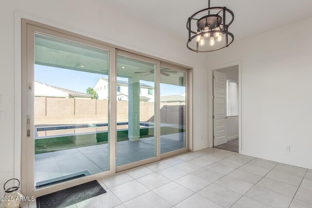 doorway featuring a notable chandelier, plenty of natural light, and light tile patterned floors