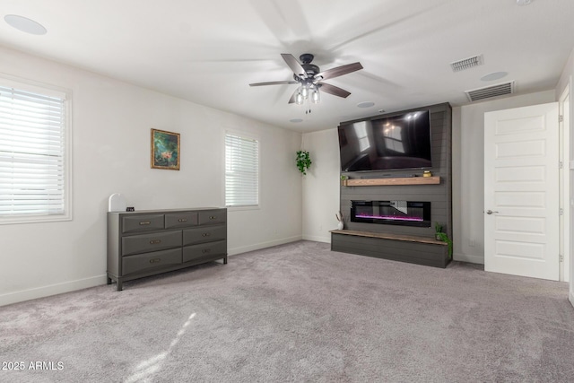 unfurnished living room with a healthy amount of sunlight, light colored carpet, and a fireplace