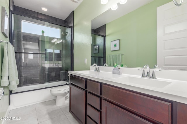 full bathroom featuring toilet, tile patterned floors, vanity, and bath / shower combo with glass door