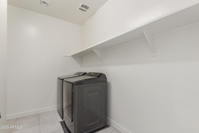 laundry area featuring separate washer and dryer and light tile patterned floors