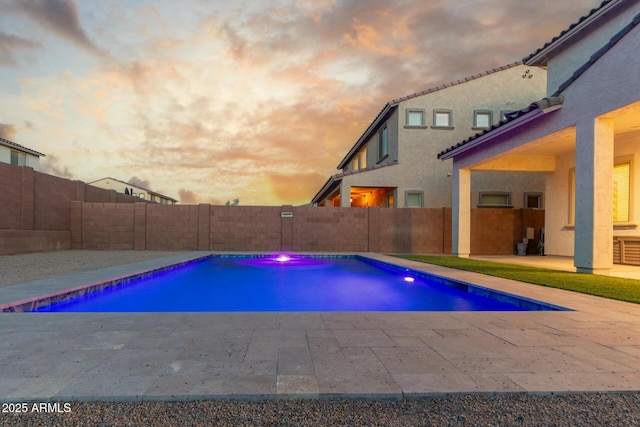 pool at dusk with a patio