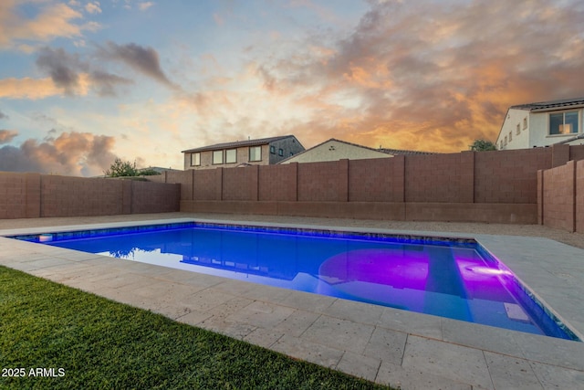 pool at dusk with a patio area