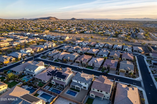 aerial view at dusk featuring a mountain view