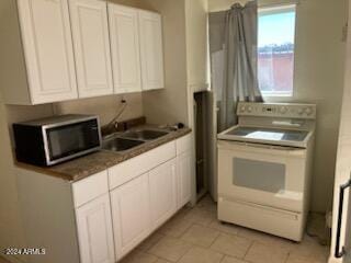 kitchen featuring white cabinetry, sink, light tile patterned floors, and white range with electric cooktop