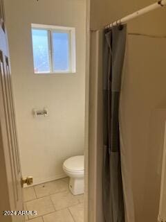 bathroom featuring toilet, a shower with shower curtain, and tile patterned flooring