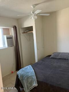 bedroom with cooling unit, a closet, and ceiling fan