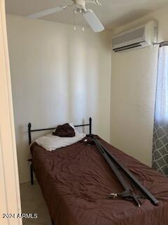 bedroom featuring a wall mounted air conditioner and ceiling fan