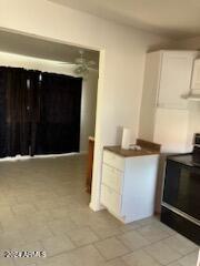 kitchen with black electric range oven and white cabinets