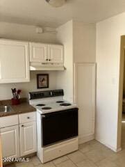 kitchen with white electric range, white cabinets, and light tile patterned floors