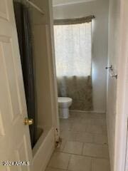 bathroom with toilet, tile patterned floors, and shower / bath combo with shower curtain