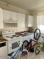 kitchen with sink, white electric range, white cabinets, and light tile patterned floors