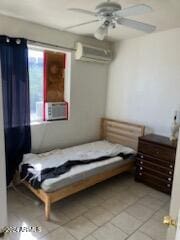 tiled bedroom with ceiling fan, cooling unit, and a wall unit AC