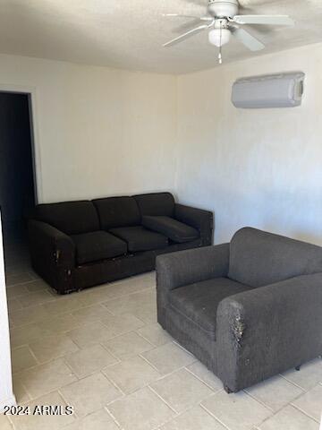 living room with an AC wall unit and ceiling fan