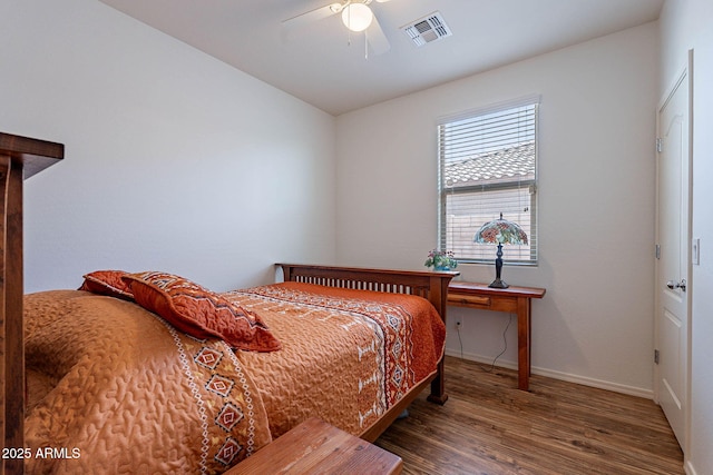 bedroom featuring wood finished floors, visible vents, a ceiling fan, and baseboards