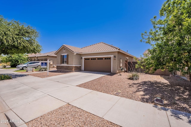 ranch-style house featuring fence, concrete driveway, a tile roof, stucco siding, and a garage