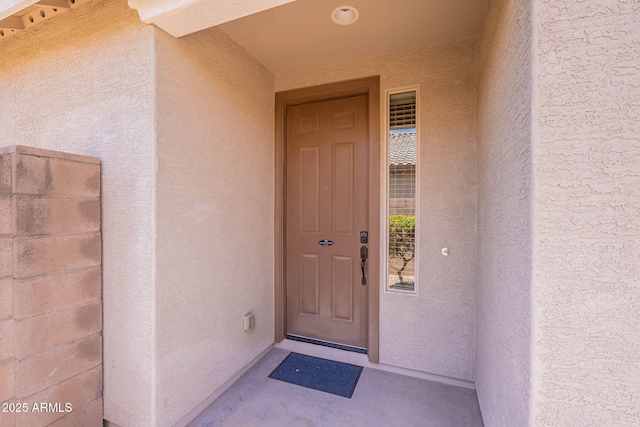 property entrance with stucco siding