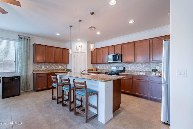 kitchen with decorative backsplash, a sink, visible vents, stainless steel appliances, and light stone countertops