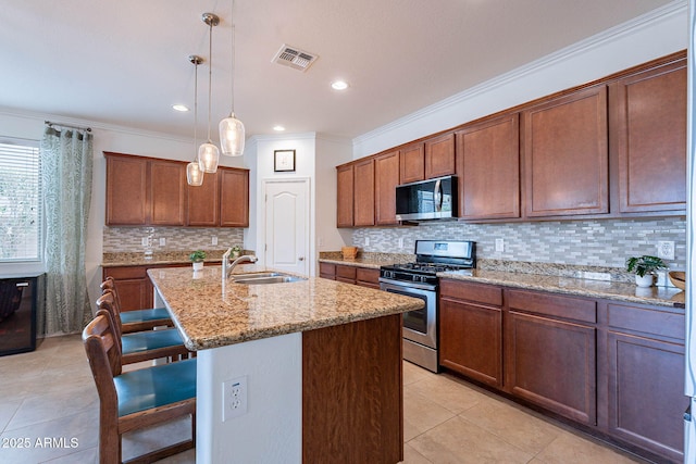 kitchen featuring a kitchen breakfast bar, light tile patterned floors, a sink, visible vents, and stainless steel appliances