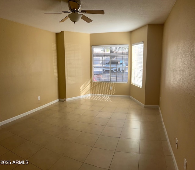 empty room with light tile patterned flooring and ceiling fan