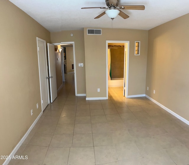 unfurnished bedroom featuring light tile patterned flooring, ceiling fan, and ensuite bath