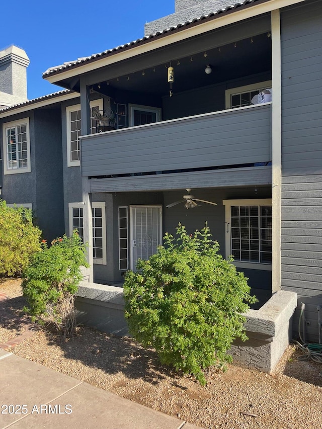 exterior space with a balcony and ceiling fan