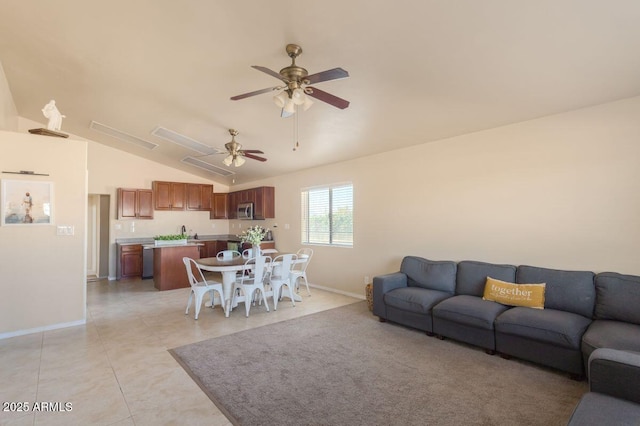 living area with baseboards, ceiling fan, vaulted ceiling, and light tile patterned floors