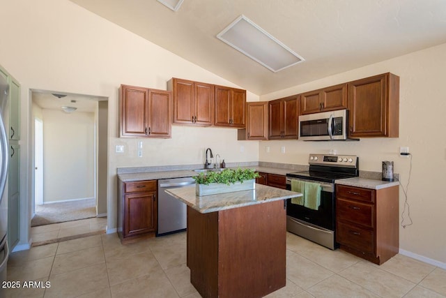 kitchen with light tile patterned flooring, a sink, appliances with stainless steel finishes, and lofted ceiling