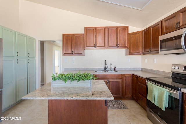 kitchen featuring vaulted ceiling, a sink, a kitchen island, appliances with stainless steel finishes, and light tile patterned floors