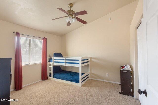 bedroom featuring a ceiling fan, carpet floors, baseboards, and lofted ceiling