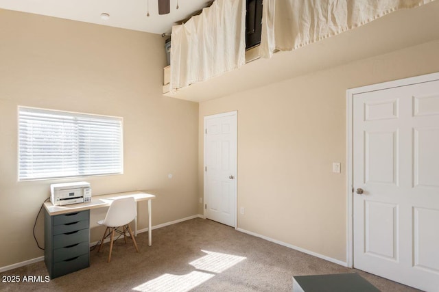 office featuring baseboards, a towering ceiling, and carpet flooring