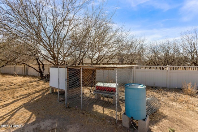 view of yard featuring exterior structure, an outdoor structure, and a fenced backyard