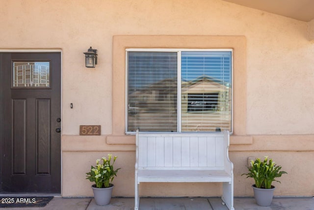 doorway to property featuring stucco siding