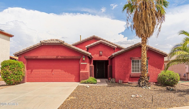 view of front of house featuring a garage, driveway, a tile roof, and stucco siding