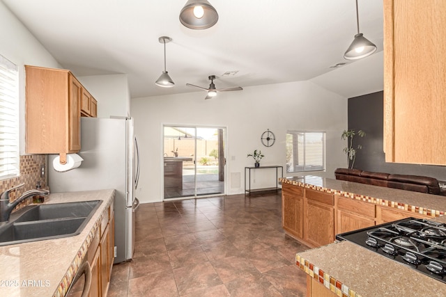 kitchen with lofted ceiling, hanging light fixtures, a sink, and light countertops